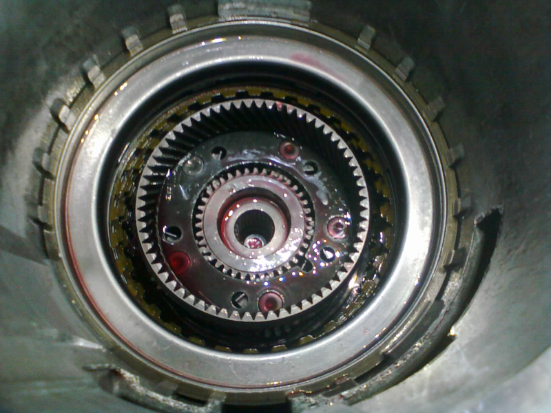 The sun gear goes into the center of the rear planetary, bearing facing down. Note the open end of the 2-4 piston housing’s snap-ring is inside the large “lug” at the top of the case. This helps keep the snap-ring from breaking.